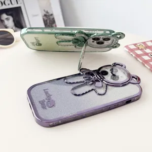 Detailed shot of electroplated glitter phone cases with cute bear and bow stand design.