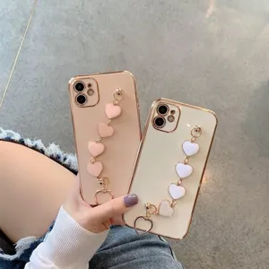 Detail close-up of electroplated heart chain phone case with stylish wristband bracket.