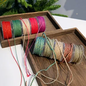 Detailansicht von metallisch geflochtener Weihnachtsschnur und Geschenkedekorationsband.