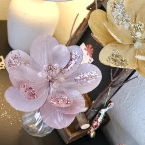 Detailansicht der glitzernden künstlichen Magnolienblüte in Rosa mit Perlen für Deko.