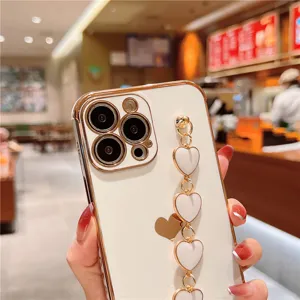 Detailed view of luxury electroplated white phone case with cute heart wrist chain for iPhone.