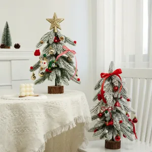 Mini künstlicher Tannenbaum mit Schnee, roten Kugeln und Stern für weihnachtliche Tischdeko.