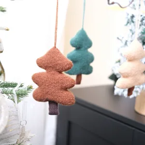 Gros plan de détails de suspensions de sapin de Noël en feutre tricoté pour une déco festive.