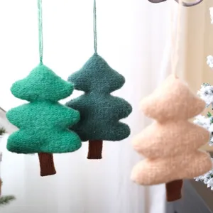 Gros plan de petits ornements suspendus en forme d'arbre de Noël tricoté pour les fêtes.