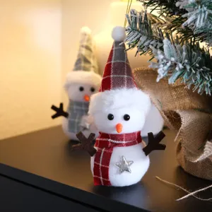 Detailed view of cute plaid snowman Christmas ornament with red hat and scarf for holiday decor.