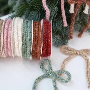 Dettaglio nastro di filato lavorato a maglia e decorazione fiocco di Natale, morbido e perfetto.