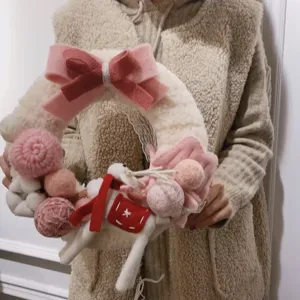 Handmade felt Christmas wreath with pink bow and cute deer decor for holiday home styling.
