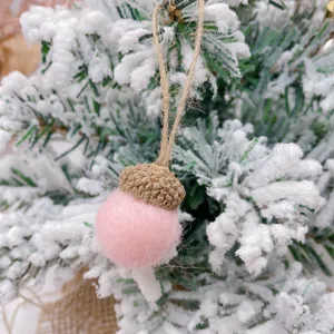 Pink felt acorn Christmas tree pendant detail shot, wool ball with natural cap for DIY decor.