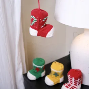 Detail view of mini knitted Christmas stockings with festive tree and candy patterns for holiday decor.