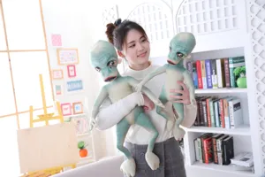 Close-up view of funny alien plush toys held by a model in a bright room detail shot.