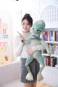 Funny alien plush toy holding doll, soft stuffed green monster pillow, creative gift.