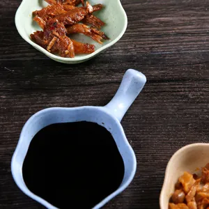 Detailed view of wheat straw seasoning dish with handle, serving soy sauce gracefully.