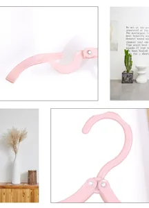 Portable pink folding clothes hanger for travel and dorm, compact plastic space saving design.