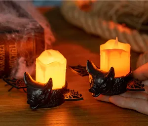 Atmospheric warm orange glow from bat-shaped Halloween LED candle lights on a rustic table