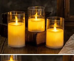 Detail of three LED flameless candles in fluted glass cylinders on vintage books.