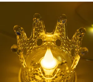 Close-up of crown-shaped LED candle with warm amber light for festive holiday ambiance.
