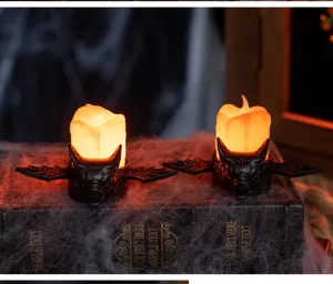 Detailed view of Halloween LED bat candle lights placed on a vintage book with spider webs.