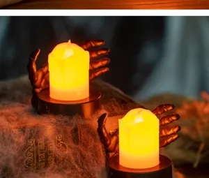 Close-up of Halloween LED candle lights with skeleton hand base and spider web decor.