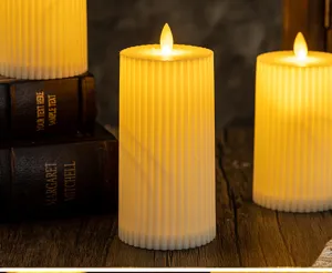 Macro detail view of ribbed white LED electronic candles with warm yellow flame glow