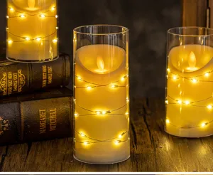 Detailed view of LED flameless candles with string lights in glass jars on vintage books