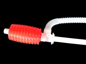 Manual car oil extractor detail view, red white plastic hand pump with flexible corrugated hose.