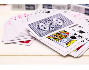 Vue détaillée de cartes à jouer étalées sur une table en bois, avec un beau motif au dos.