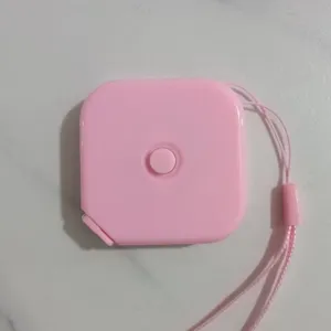 Metro a nastro retrattile quadrato rosa con cordino per cucito e misurazione del corpo.