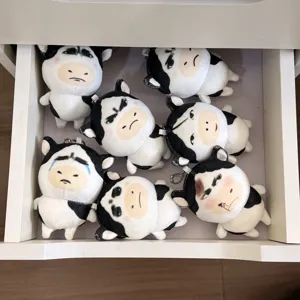 Cute cartoon black and white cow plush toy keychain with funny meme expressions, soft stuffed pendant.