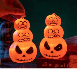 Vue détaillée de lanternes LED citrouille d'Halloween empilées avec lumière chaude.