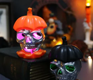 Close-up of glowing Halloween skull lights with orange and black pumpkin hats.
