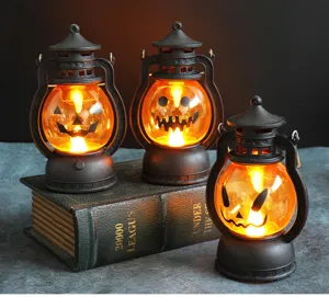 Détail de trois lanternes LED citrouille d'Halloween sur un livre décor