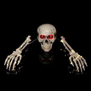 Macro view of glowing skull and skeletal hands with warm LED lights for Halloween