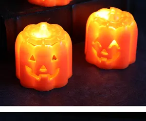 Nahaufnahme leuchtender orangefarbener Halloween LED Kürbislichter auf dunklem Hintergrund