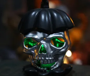 Macro view of silver Halloween skull light with spooky green glowing eyes detail
