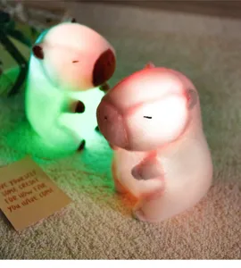 Close-up detail of glowing capybara night light glowing in dark warm room setting detail view.