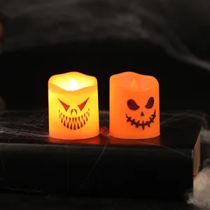 Two Halloween LED electronic candles with spooky pumpkin faces on spider web background