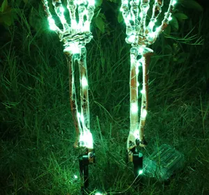 Gedetailleerd beeld van lichtgevende Halloween skelet hand gazonpennen met LED lampjes