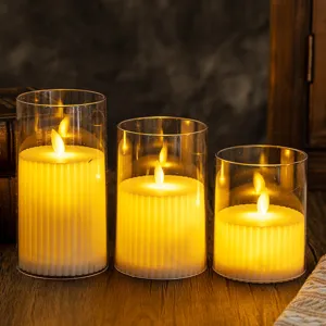 Set of three flameless LED pillar candles in glass cylinders for warm room ambiance