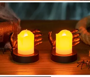 Detailed view of Halloween skeleton hand LED tea light candles on a wooden table