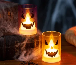 Close-up of Halloween LED candle lights with glowing Jack-o'-lantern faces in a spooky setting.