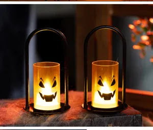 Spooky Halloween LED pumpkin candle lights displayed on a vintage book with cobwebs