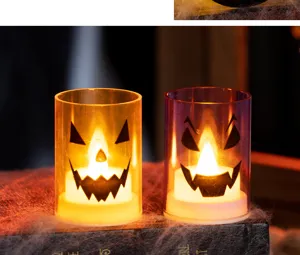 Atmospheric close-up of decorative Halloween LED candle lights with spooky pumpkin faces on a book