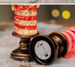 Dettaglio della base e dell'interruttore di una candela LED glitterata a righe rosse