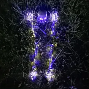 Leuchtende Halloween-Skelett-Erdspieße mit lila LED-Lichtern auf dem dunklen Rasen