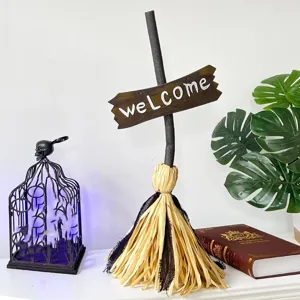 Dekorativer Halloween Hexenbesen mit Welcome Schild auf einem weißen Kaminsims platziert
