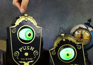 Detalle del timbre electrónico de Halloween con un ojo verde brillante y luz LED de terror