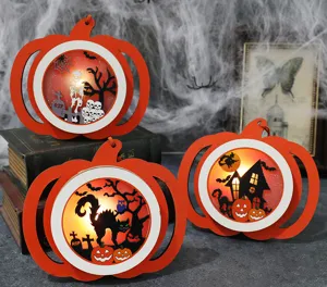 Detail view of three illuminated Halloween LED pumpkin ornaments with spooky graveyard scenes