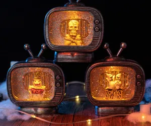 Dettaglio di tre ornamenti TV di Halloween luminosi con teschio e figure di fantasmi.