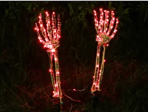 Atmospheric red LED lit skeleton hand stakes for Halloween garden outdoor decoration.