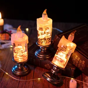 Set of three warm glow Halloween LED candles with skull and ghost designs on vintage books